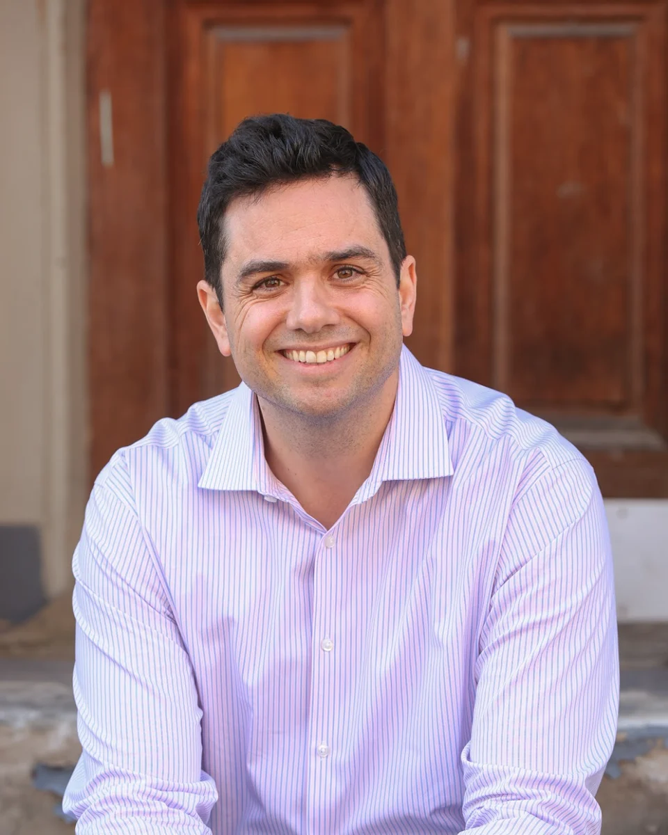 Aaron Barker smiling, sitting on front steps